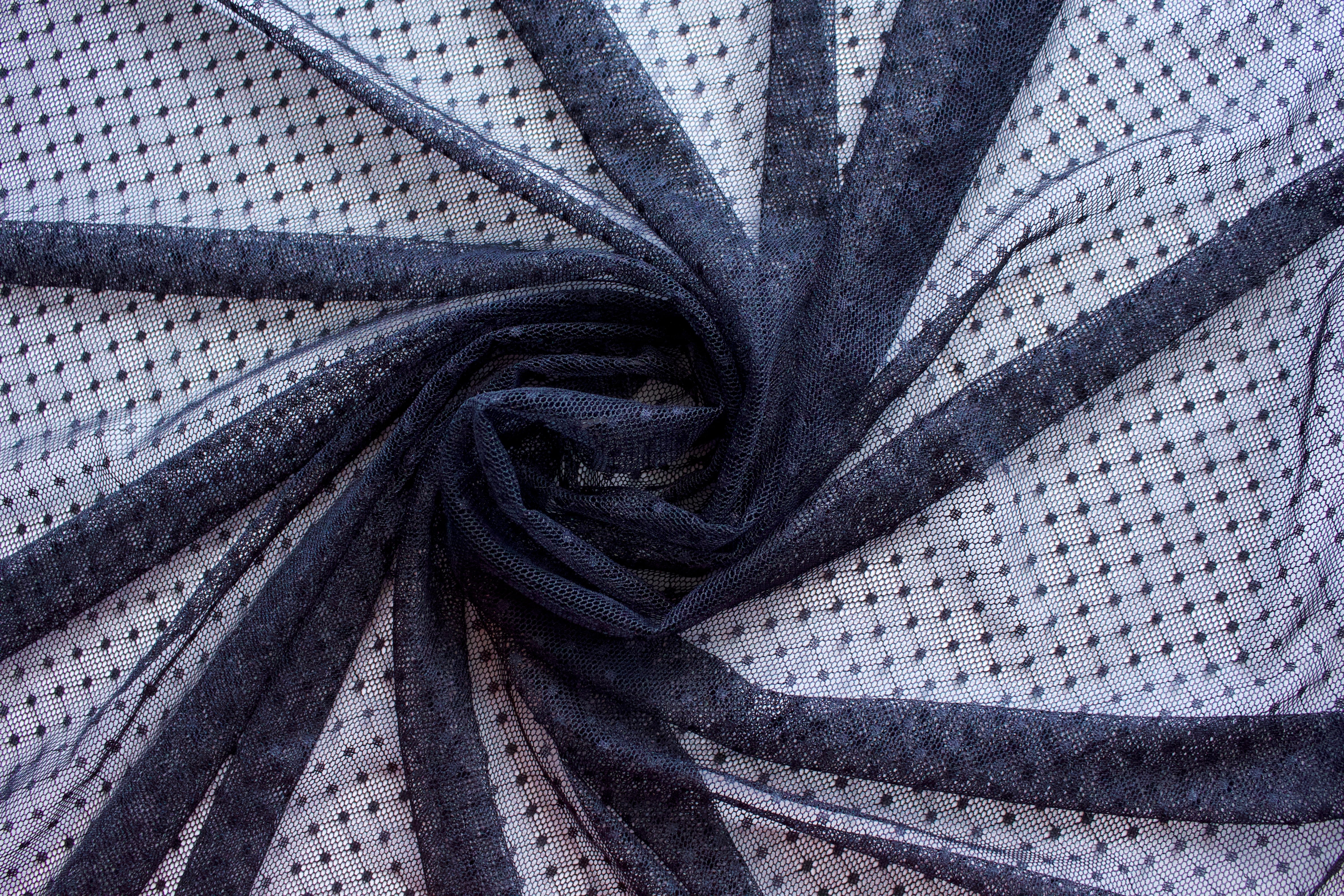 Close up of a dotted lace fabric in the color black from Rubies Custom Bras. Book a online fitting appointment to have a custom bra made today. A custom bra is worth the price because it is custom made to fit and made to last years.
