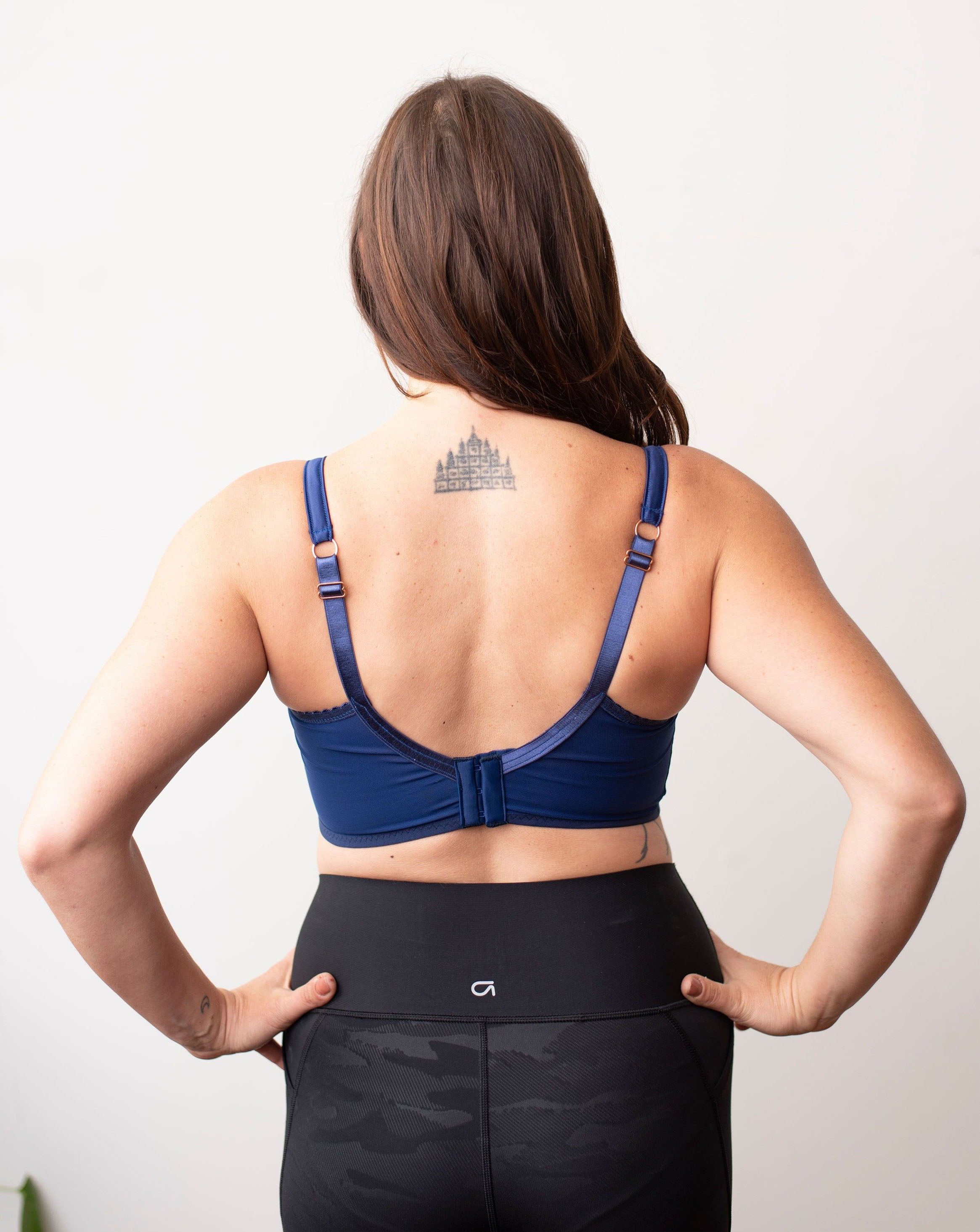 Back shot of model wearing navy blue minimal solid bra against a plain white background.