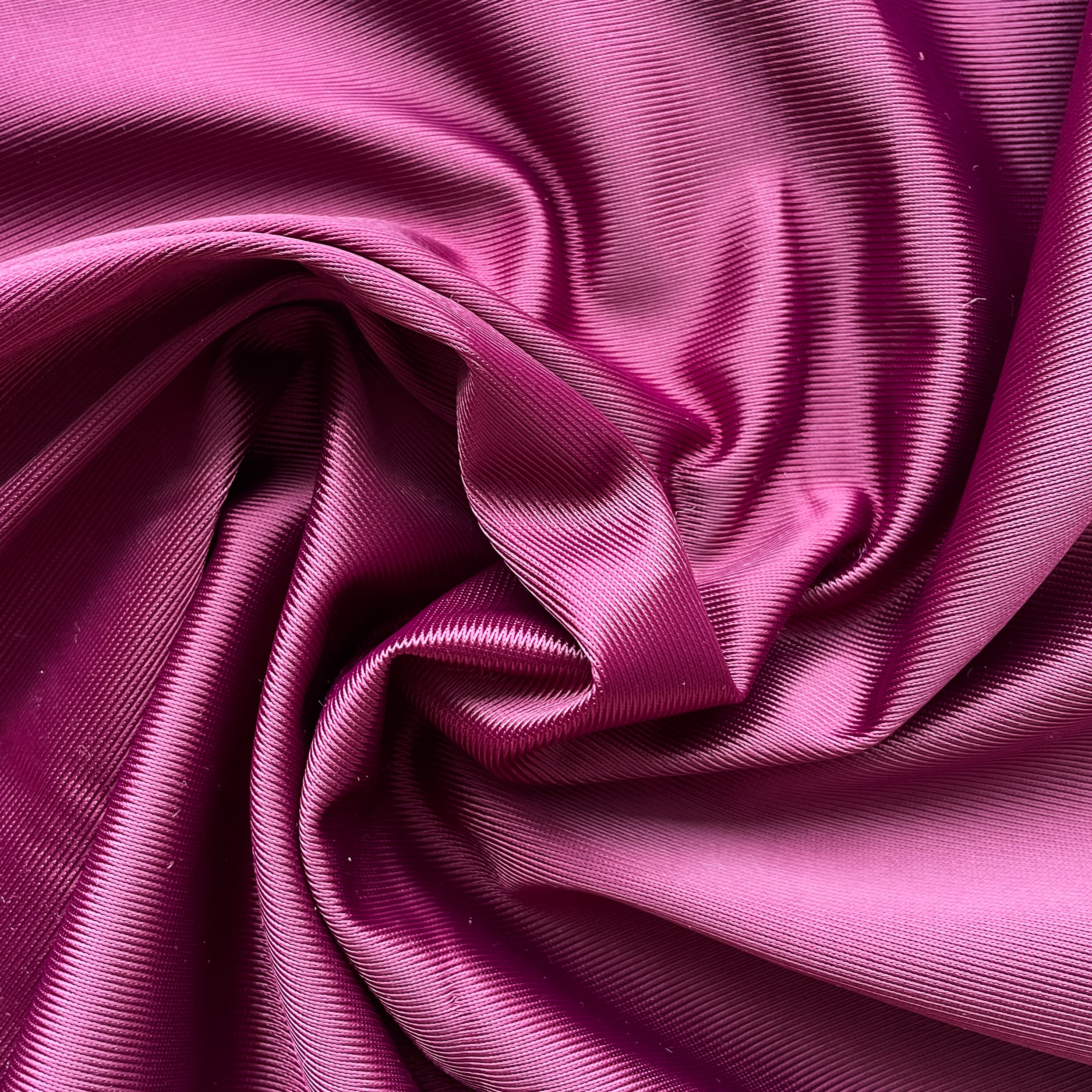 Close up of a soft satin fabric in the color black cherry from Rubies Custom Bras. We use only the softest bra materials that won't itch or cause allergies. Our fabrics are long lasting and high quality. Book a online fitting appointment to have a custom bra made today. A custom bra is worth the price because it is custom made to fit and made to last years.