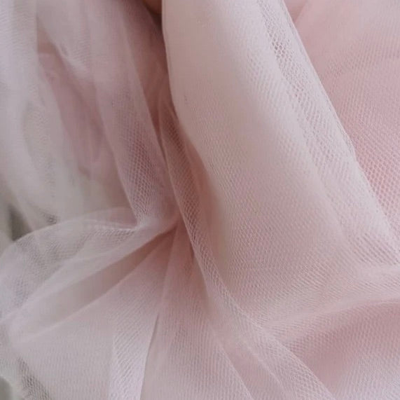 Close up of tulle in the color peach from Rubies Custom Bras. Our fabrics are long lasting and high quality. Book a online fitting appointment to have a custom bra made today. A custom bra is worth the price because it is custom made to fit and made to last years.