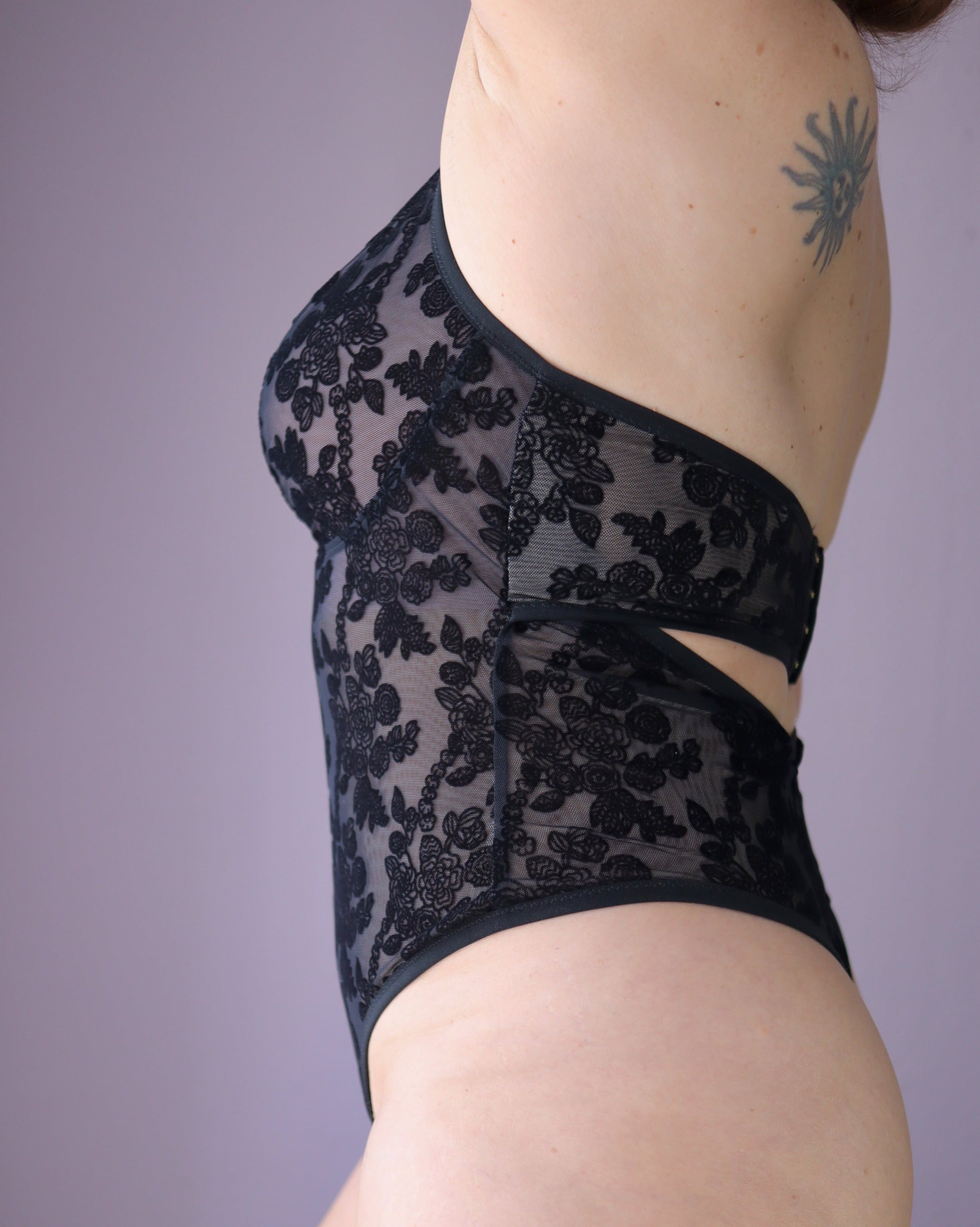 Rubies Custom Bras: Side shot of our custom bespoke bodysuit in black sheer velvet. Made to order and made to measure in Canada and USA. Book an online fitting with an bra fit specialist and expert. Specializing in asymmetry, mastectomy, nursing, large cup sizes, and other special needs.