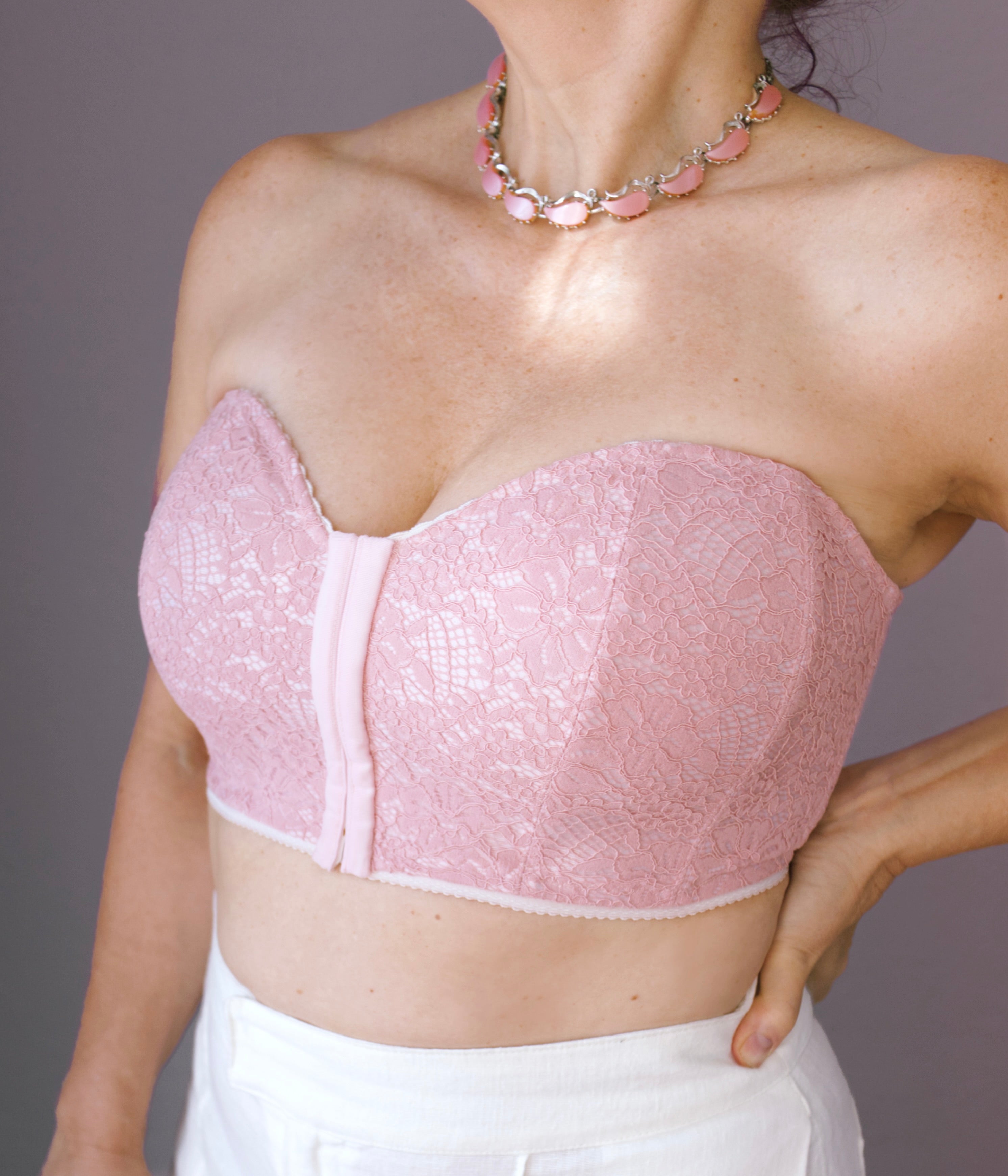 A model wearing a strapless bustier in pink from Rubies Custom Bras