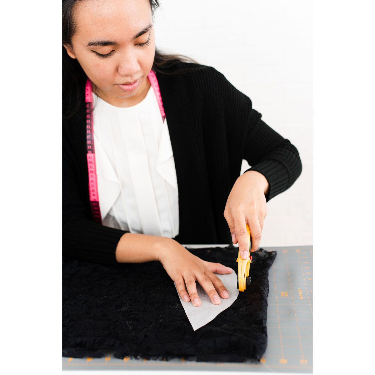 Rubies Bras sewing staff with dark hair cutting out a bra pattern.