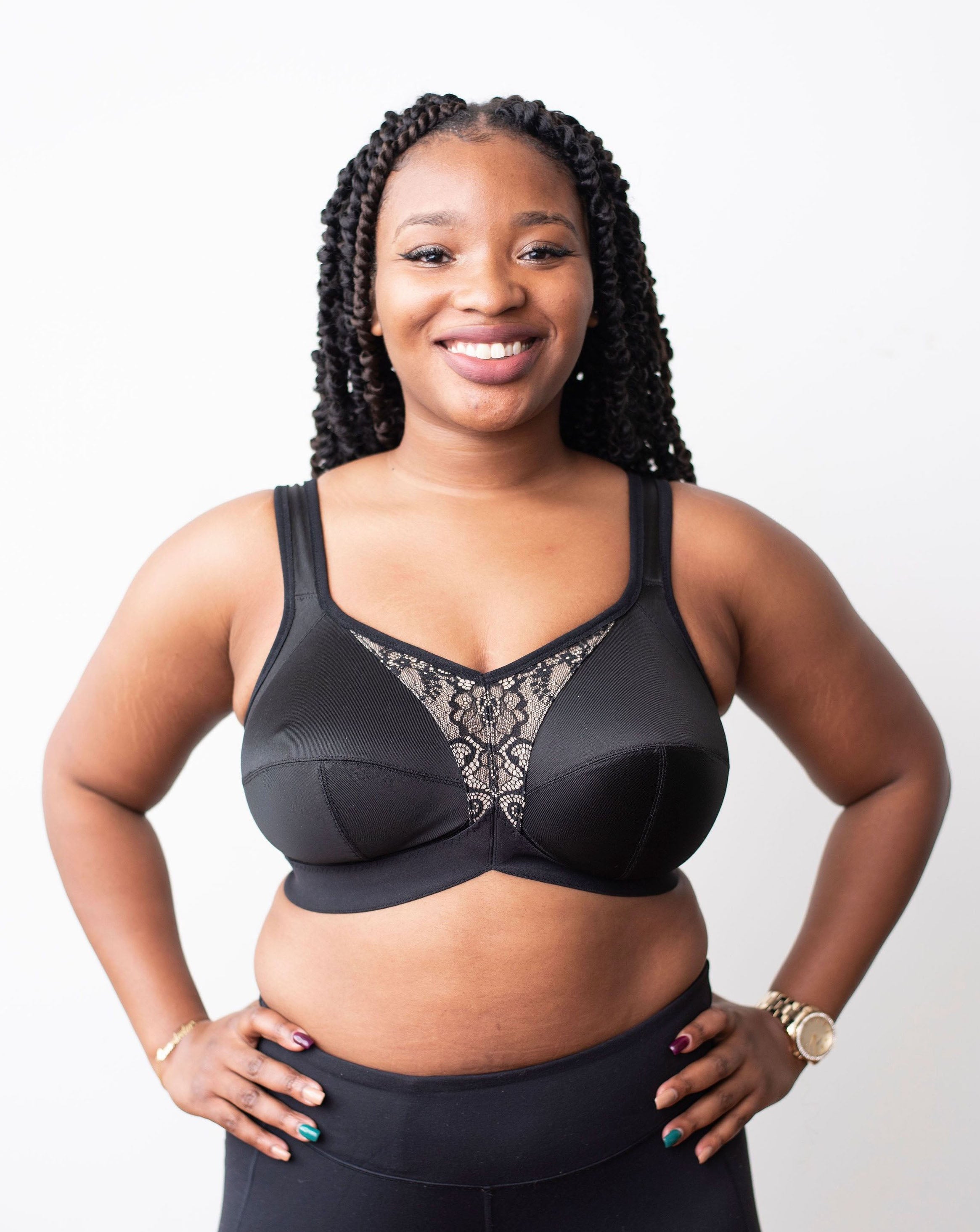 Lia from Rubies Bras, a female with long braided hair, is wearing a black Ingrid solids full coverage bra and black pants. Front shot on white back drop.