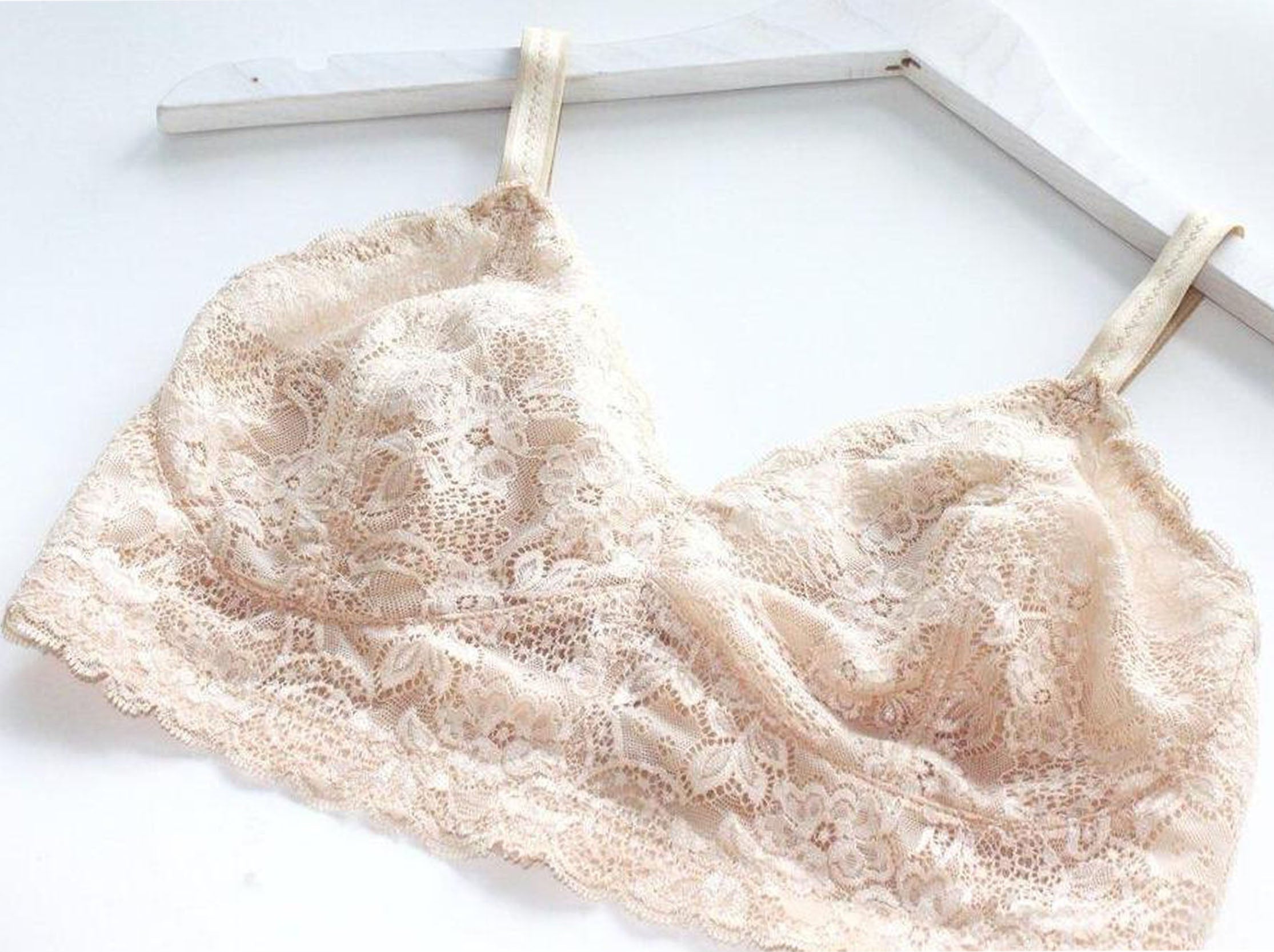 Custom made wireless bra in beige scalloped lace fabric on a hanger, made to order by Rubies Bras.