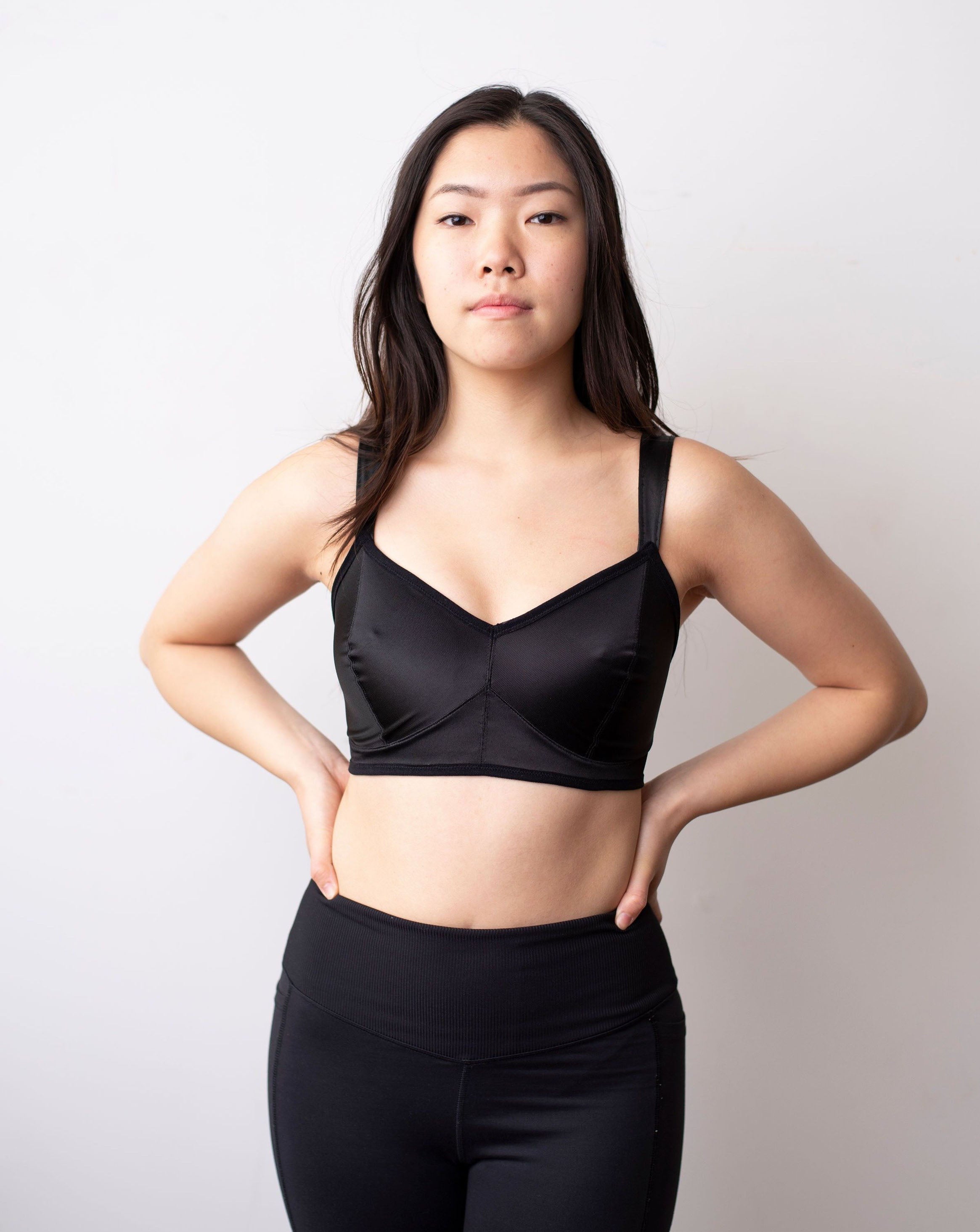 Front shot of black haired model wearing a black minimal solids bra.