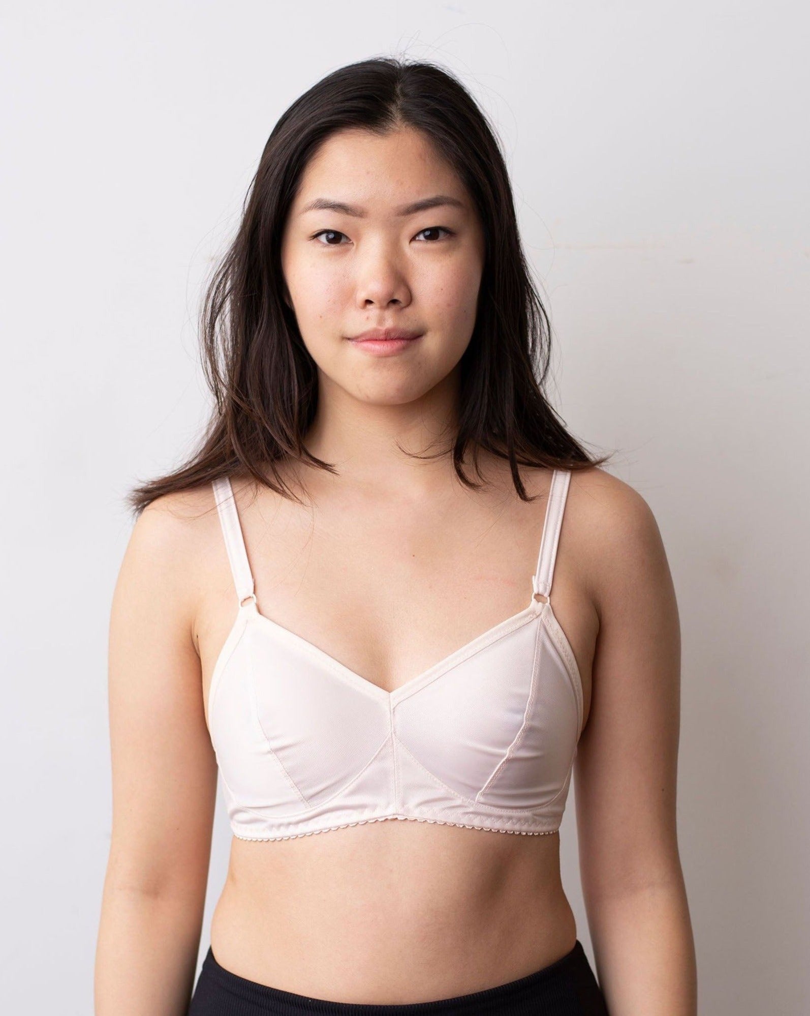 Front shot of a black haired model wearing a white Viva solids bra from Rubies Custom Bras