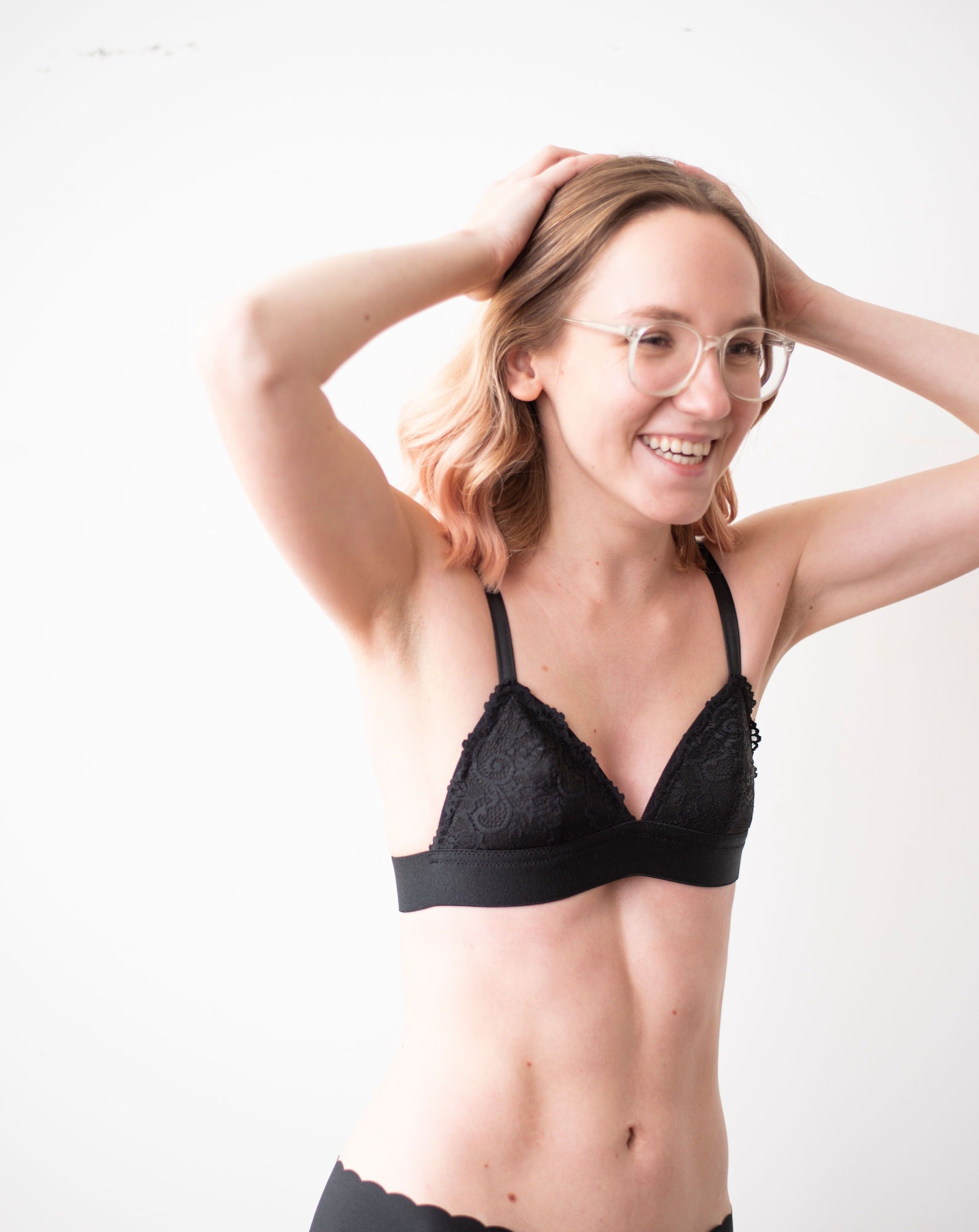 Haley from Rubies Bras, a female with medium blond hair wearing a peach and white wirefree bra from our petites collection. Half body shot on white back drop.