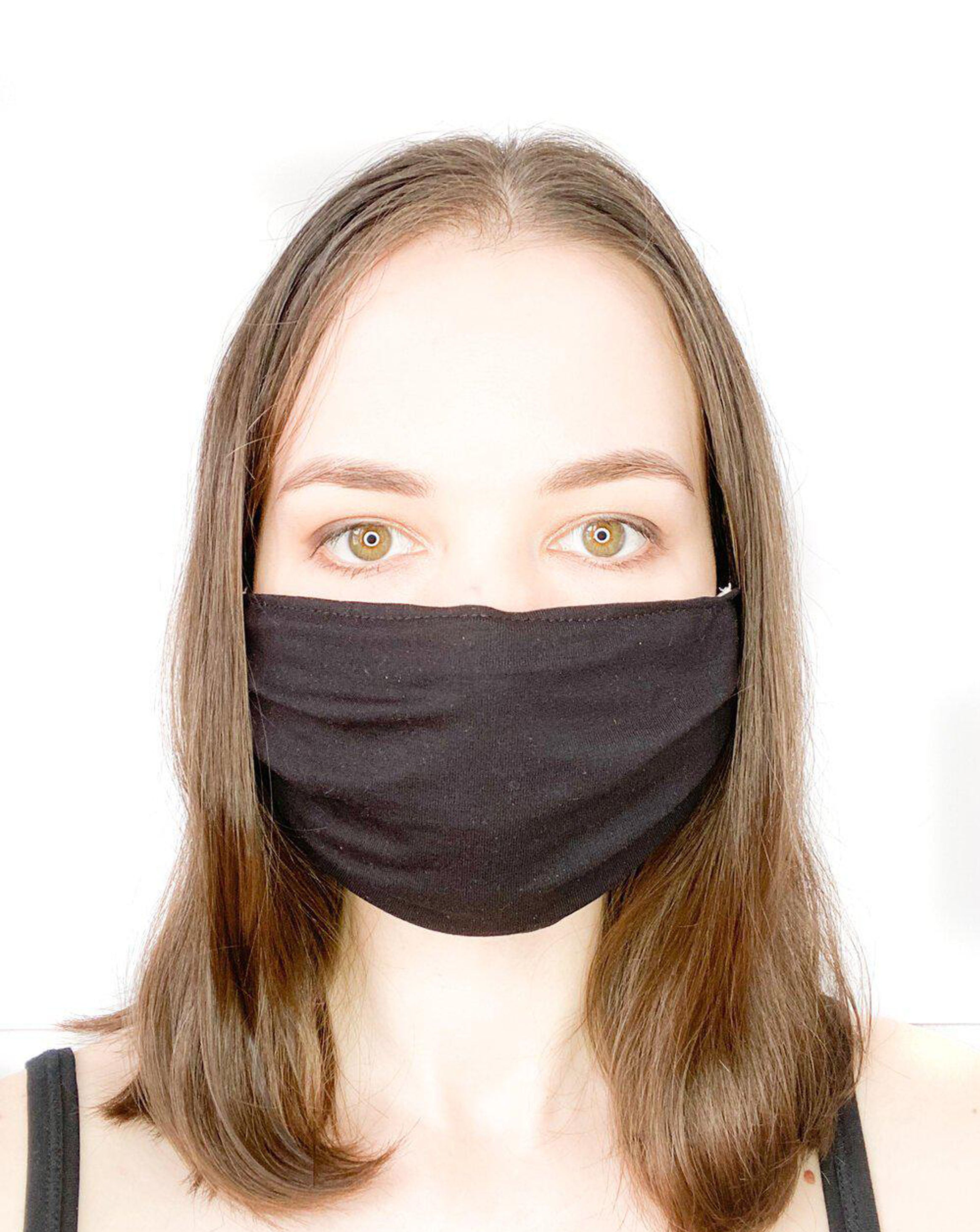 Model with brown hair wearing a black, organic cotton facemask.