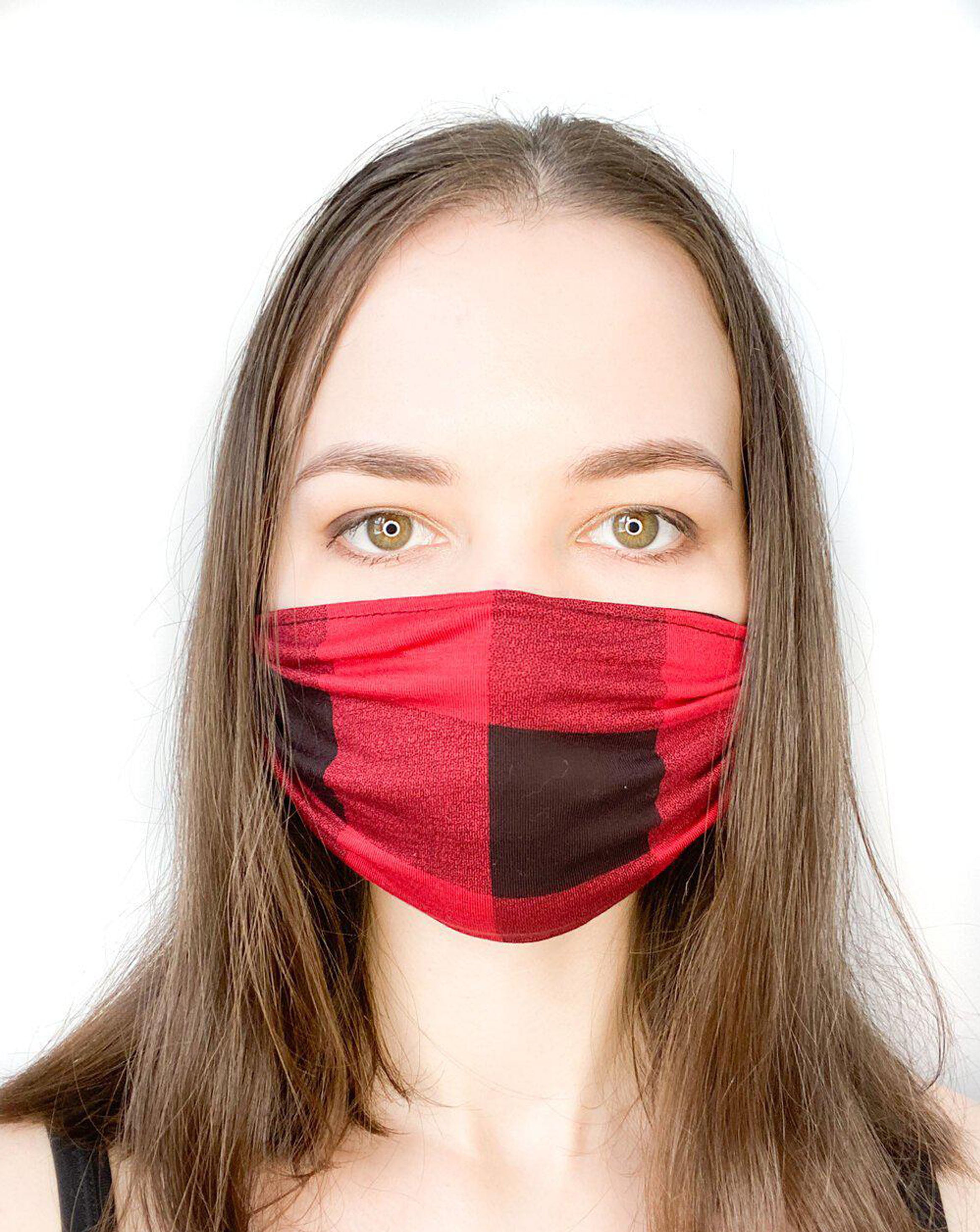 Model with brown hair wearing a black and red plaid, organic cotton facemask.